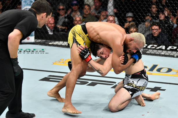 Deiveson Figueiredo of Brazil works for a guillotine choke against Brandon Moreno of Mexico in their UFC flyweight championship fight during the UFC...