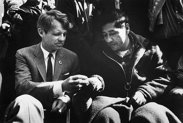 Robert Kennedy breaks bread with
            Cesar Chavez