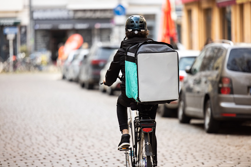 Delivery person with thermal box on a bicycle in town