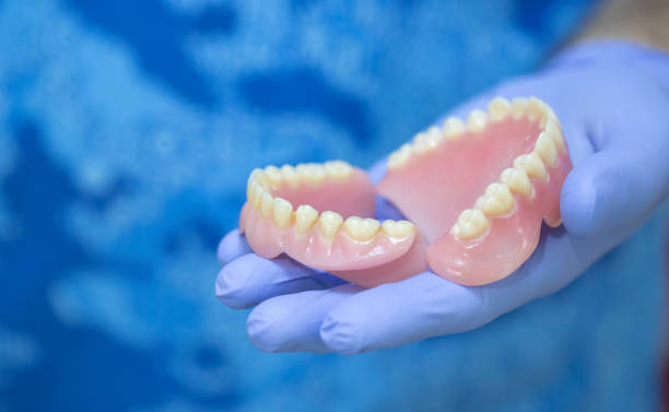 dentist holding denture - dentures stock pictures, royalty-free photos & images