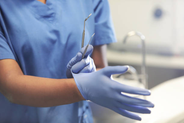 dentist putting gloves on - dentista - fotografias e filmes do acervo