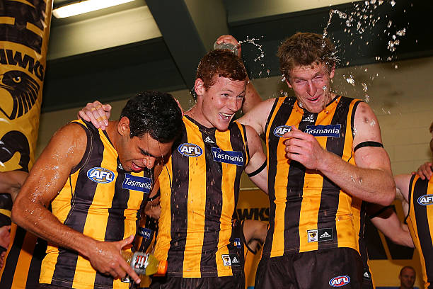 Derrick Wanganeen Tim O'Brien and Ben McEvoy of the Hawks celebrates his first win with the club during the round one AFL match between the Hawthorn...