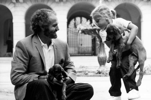 Designer Gianni Versace playing with niece Francesca and puppies.