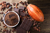 Detail of cocoa fruit with pieces of chocolate and cocoa powder on raw cocoa beans