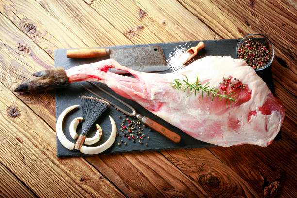 detail of raw meat thigh of wild boar on a black plate with rosemary picture