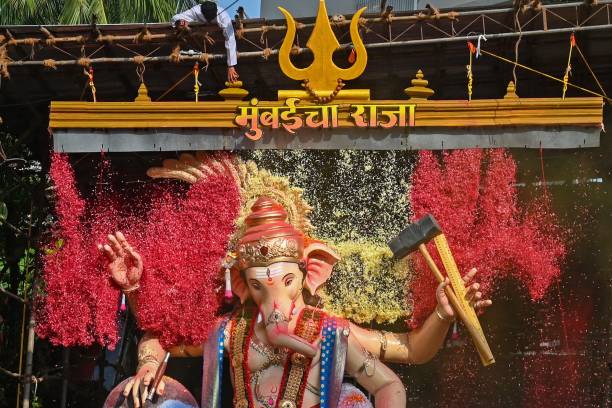 Devotees shower flower petals on an idol of the elephant-headed Hindu deity Ganesha during an immersion procession to the Arabian sea on the last day...