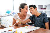 Disabled Latino teenager with Celebral Palsy and mother laughing.