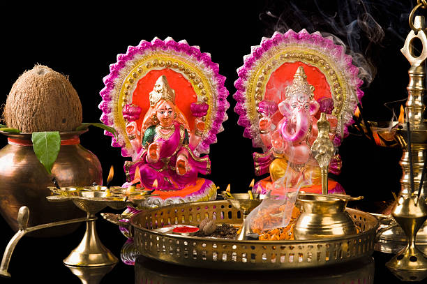 diwali thali in front of idols of lord ganesha and goddess lakshmi - laxmi ganesh stock pictures, royalty-free photos & images