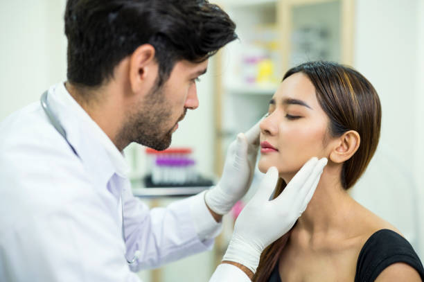 doctor examining and explaining asian women patient's face for improvement of her skin at a beauty clinic. skin care clinic business. - dermatologista - fotografias e filmes do acervo