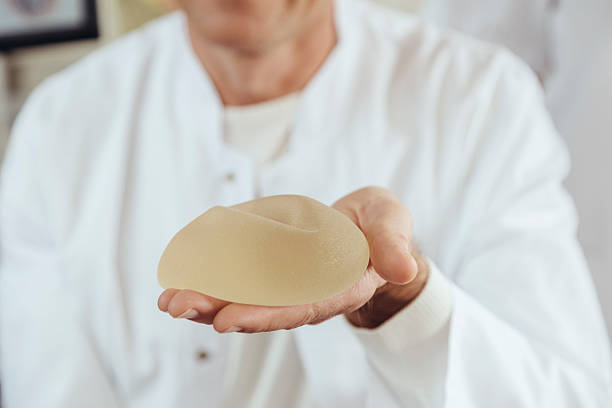 doctor showing a silicone breast implant - prótese de silicone - fotografias e filmes do acervo