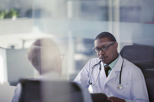 doctor talking with patient at desk in office picture