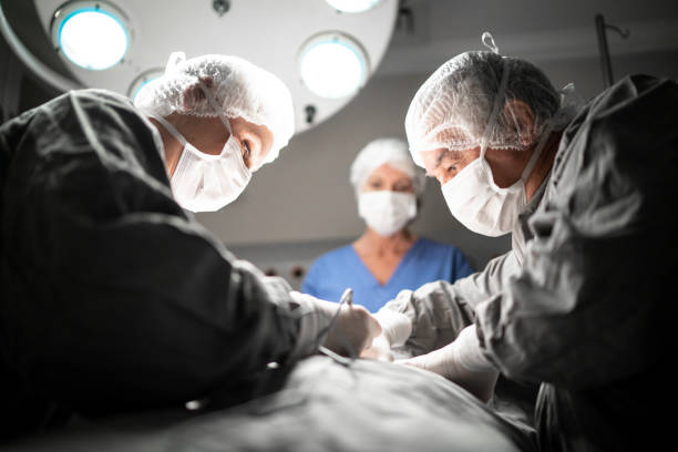 médicos fazendo uma cirurgia na sala de cirurgia no hospital - lipoaspiração - fotografias e filmes do acervo