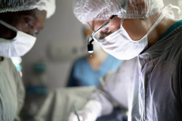 médicos fazendo uma cirurgia na sala de cirurgia no hospital - cirurgiões plásticos - fotografias e filmes do acervo