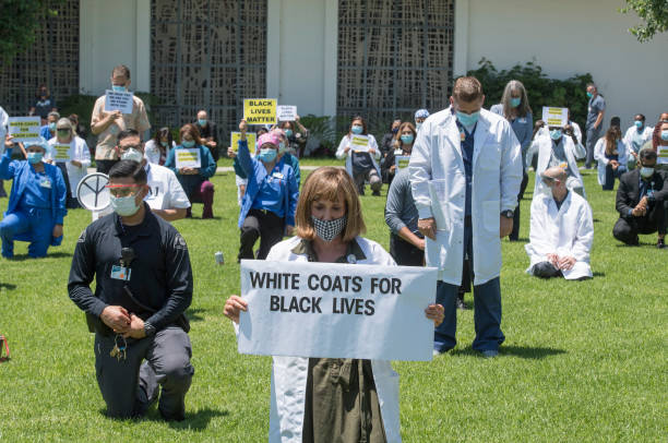 Doctors, nurses and other health care workers participate in a "White Coats for Black Lives" event in solidarity with George Floyd and other black...