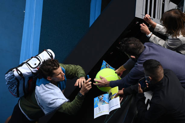 Dominic Thiem of Austria signs autographs following victory in his Men's Singles first round match against Mikhail Kukushkin of Kazakhstan during day...