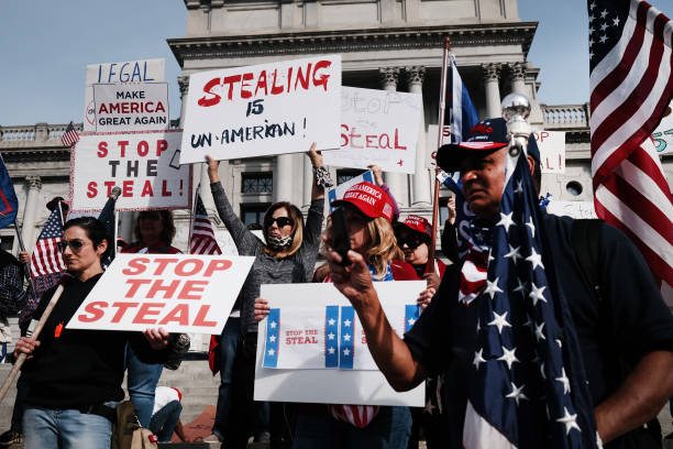 Dozens of people calling for stopping the vote count in Pennsylvania due to alleged fraud against President Donald Trump gather on the steps of the...