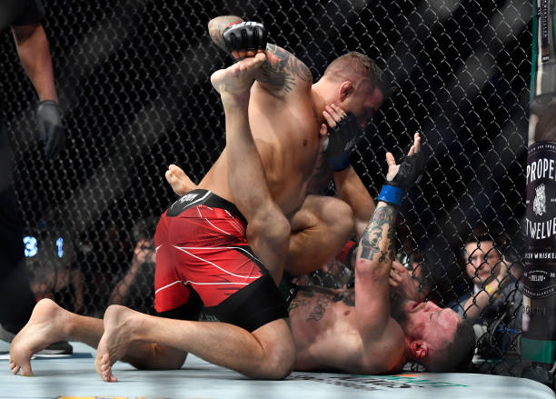 Dustin Poirier punches Conor McGregor of Ireland in their welterweight fight during the UFC 264 event at T-Mobile Arena on July 10, 2021 in Las...