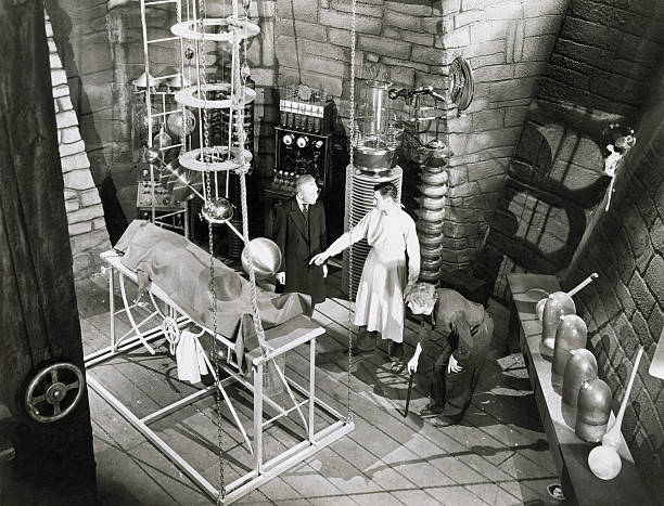 Edward Van Sloan as Dr. Waldman, Colin Clive as Dr. Henry Frankenstein, and Dwight Frye as his assistant Fritz, preparing to bring their monster to...