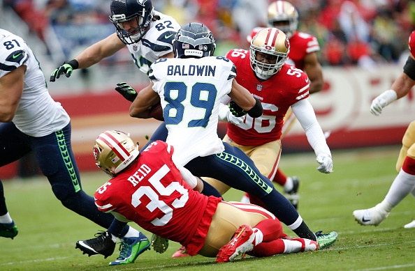eric reid of the san francisco 49ers tackles doug baldwin of the picture