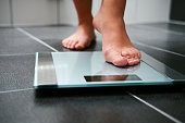 Female bare feet with weight scale