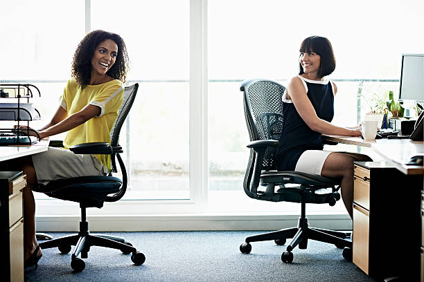 female coworkers laughing - cadeira de escritório - fotografias e filmes do acervo