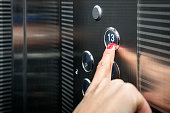 Female in the suit pushing the button it the elevator. Close-up photo of a smart girl, who is an office worker, pushing the lift's button.