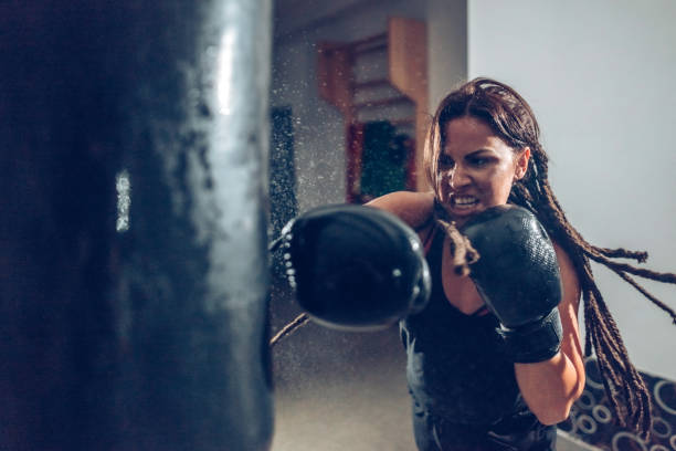kickboxer hembra capacitación con una bolsa de boxeo