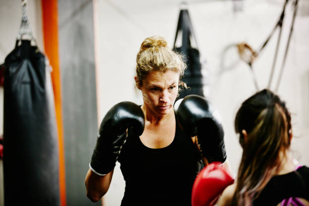Female kickboxers training together in gym