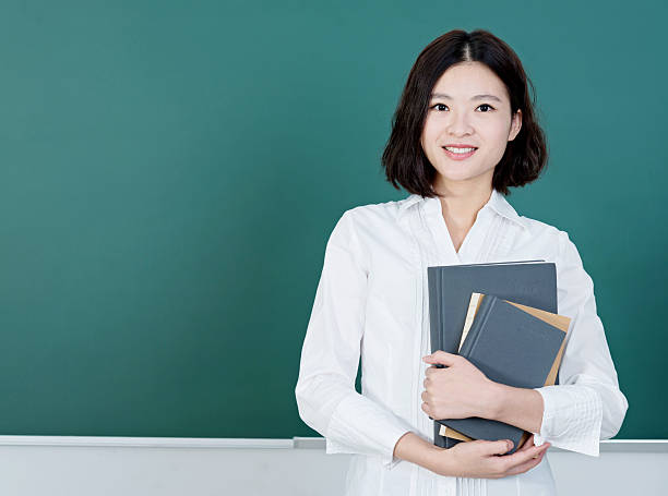 female teacher in front of chalkboard - pretty asian teacher stock pictures, royalty-free photos & images