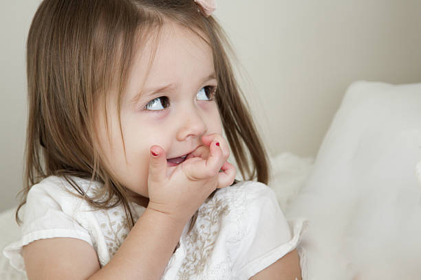 female toddler biting her nails - biting nails in kids stock pictures, royalty-free photos & images