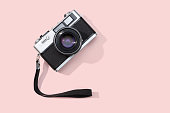 Flat lay film camera isolated on pink background