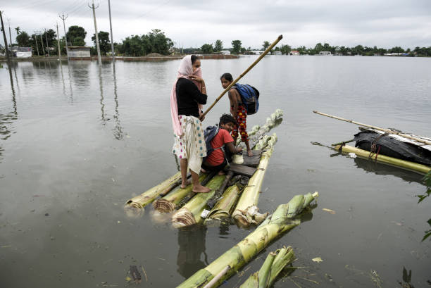 Flood affected people coming towards a safer place using a banana raft, at a village on June 17, 2022 in Barpeta, India. Assam flood situation...