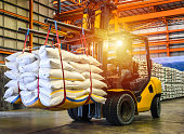 Forklift handling sugar bags for stuffing into container for export.