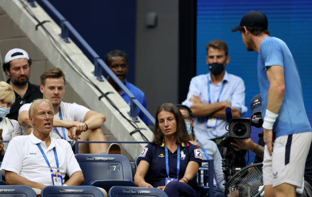 Former chair umpire Gerald Armstrong speaks with Andy Murray of United Kingdom against Stefanos Tsitsipas of Greece during their men's singles first...