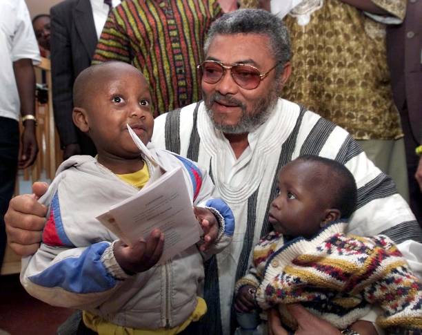 Former Ghanaian President Jerry Rawlings poses 29 September 2001 with fiveyearold Dickson Mungai and 18monthold Edel Wanjiru both HIV positive at the...