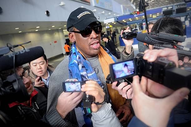 Former US NBA basketball player Dennis Rodman speaks to members of the media as he makes his way through Beijing's international airport on December...