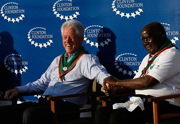 Former US President Bill Clinton holds hands with Zambia President Kenneth Kaunda during an event at a youth outreach soccer tournament hosted by...