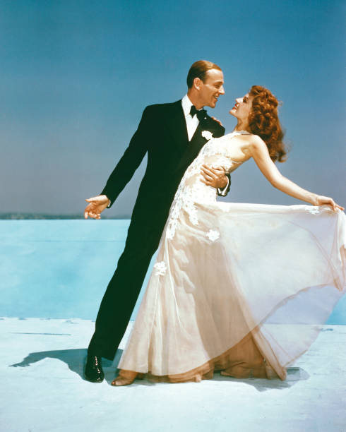 Fred Astaire , US actor and dancer, wearing a black dinner suit and bow tie, and Rita Hayworth , US actress and dancer, wearing a flowing white...