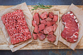 Fresh raw angus beef meat, whole, ground and chopped on parchment paper