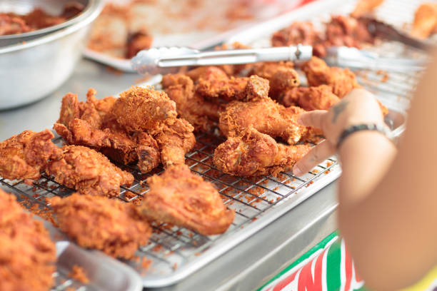 frying chicken cooking deep fried chicken. - deep fried chicken stock pictures, royalty-free photos & images