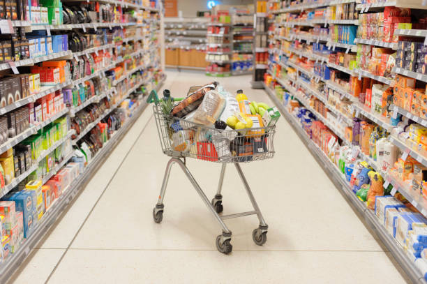 full shopping cart in supermarket aisle picture