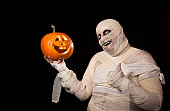 Funny halloween mummy with smiling pumpkin