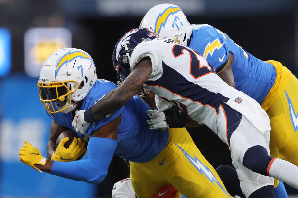 Gerald Everett of the Los Angeles Chargers is brought down by Kareem Jackson of the Denver Broncos during the second quarter at SoFi Stadium on...