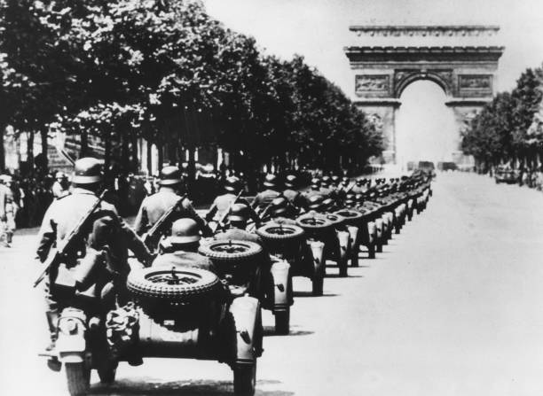 German soldiers on the Champs Elysees, Paris, 14 June 1940. A column of German troops in motorcycles with sidecars heading towards the Arc de...