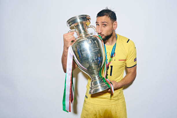 Gianluigi Donnarumma of Italy poses with The Henri Delaunay Trophy during an Italy Portrait Session following their side's victory in the UEFA Euro...