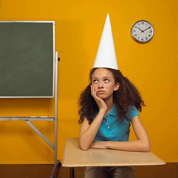 girl in dunce cap - student punishment stock pictures, royalty-free photos & images