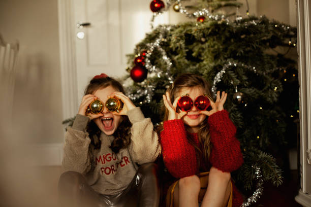 girls in front of christmas tree - natal  - fotografias e filmes do acervo