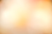 Golden orange colored blurred background .Abstract blur glowing orange gold of morning sky color tone background with white sunshine light effect for design as banner,presentation,ads concept