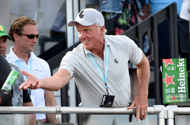 Golf commissioner Greg Norman tosses beers to the gallery from the deck of a pavilion on the 18th green during the final round of the LIV Golf...