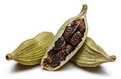 Green cardamom pods and seeds on white background